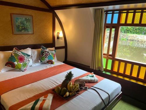 a bedroom with a bed with a tray of fruit on it at Traditional Houseboat in Alleppey