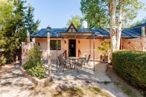 a patio with a table and chairs in front of a house at Complejo Ermitazh in Valle Grande