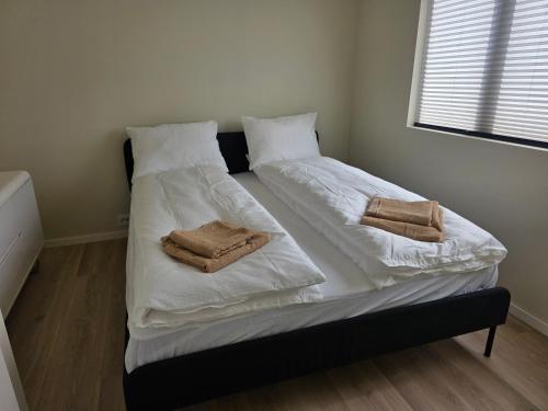 two beds in a room with white sheets and towels at Fjordstay in Vennesla