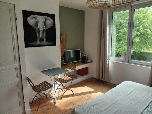 a bedroom with an elephant picture on the wall at La Canardière in Pendé