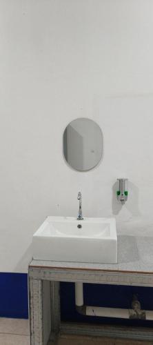 a white sink in a bathroom with a mirror at Hana hostel in Labuan Bajo