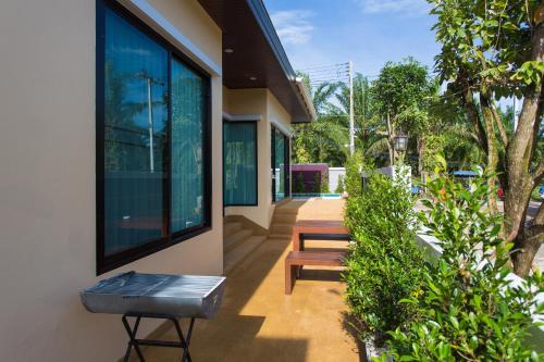 un bâtiment avec deux bancs sur le côté dans l'établissement PB Pool Villa, à Ao Nang Beach