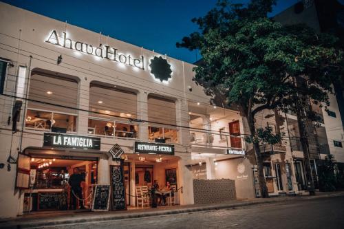 a building with a restaurant on the side of a street at Ahava Hotel in Playa del Carmen