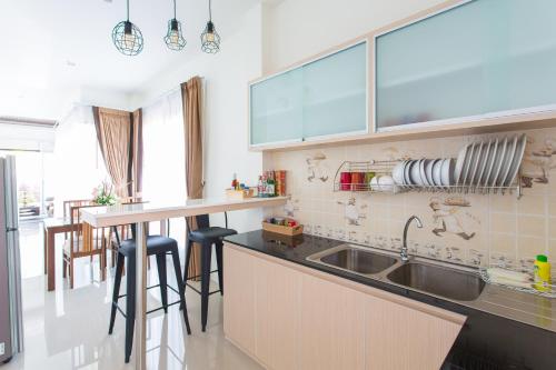 een keuken met een gootsteen en een aanrecht met krukken bij PB Pool Villa in Ao Nang Beach