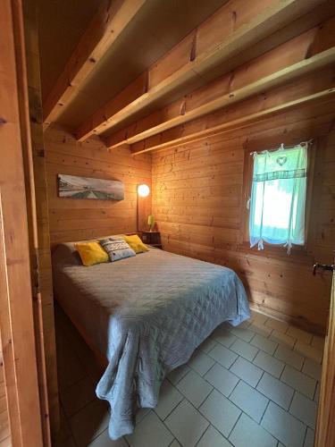a bedroom with a bed in a wooden cabin at La Roche du Moulin in Saint-Moré