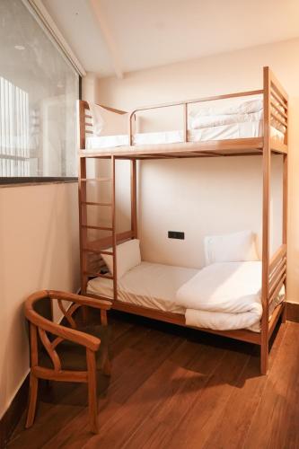 a room with two bunk beds and a chair at Hotel Chhaya in Rishīkesh