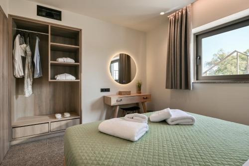 a bedroom with a bed with two towels on it at Vagg Villas in Preveza