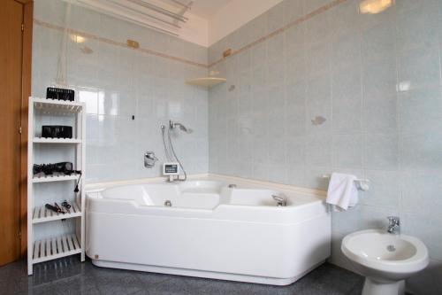a white bath tub in a bathroom with a toilet at CASA di CRISTOF ISEO in Lovere
