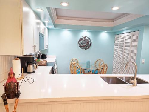a kitchen with blue walls and white counter tops at Nautical Adventures in Paradise in Key West