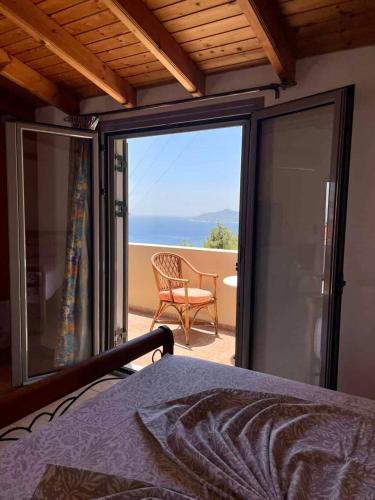 a bedroom with a balcony with a view of the ocean at Samos Panorama Hills in Pythagoreio