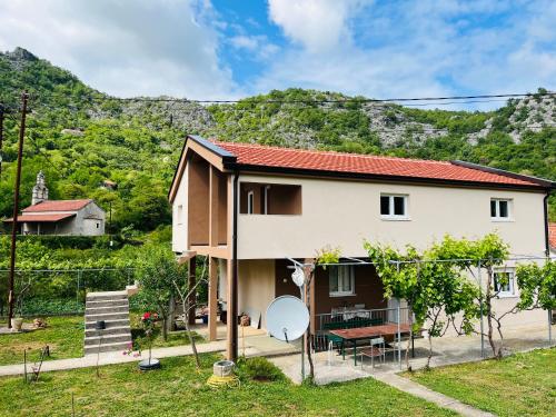 a house with a mountain in the background at Djekljak House in Virpazar