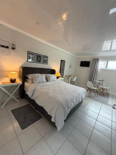 a bedroom with a large bed and a table and chairs at The Ceed in Beacon Bay