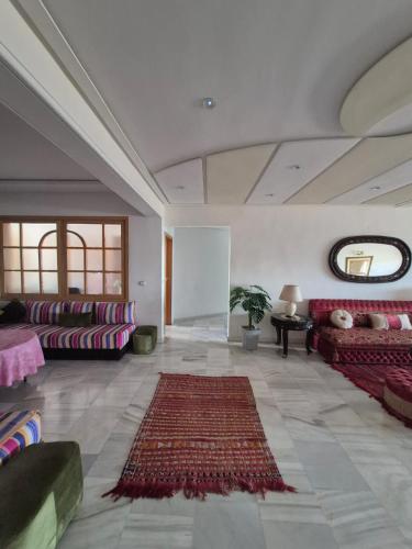 a large living room with couches and a rug at Apartment Konouz Meknes in Meknès