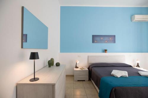 a bedroom with a bed and a blue light at Pozzallo yellow house,5'dal mare in Pozzallo