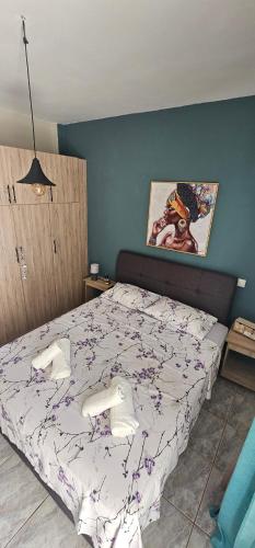 a bedroom with a bed and a painting on the wall at Alora House in Kefalos