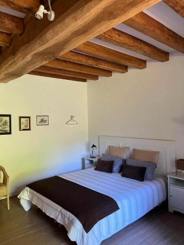 a bedroom with a large bed with wooden ceilings at L'Aveneau - Havre champêtre avec piscine d'été in Le Retail