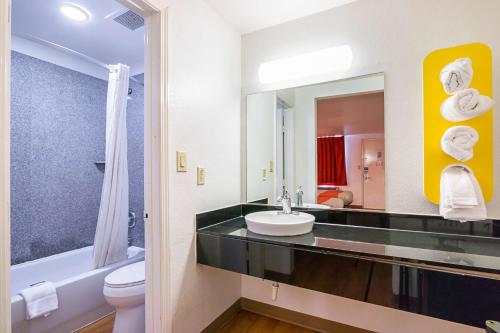 a bathroom with a sink and a toilet and a mirror at Motel 6-Round Rock, TX in Round Rock
