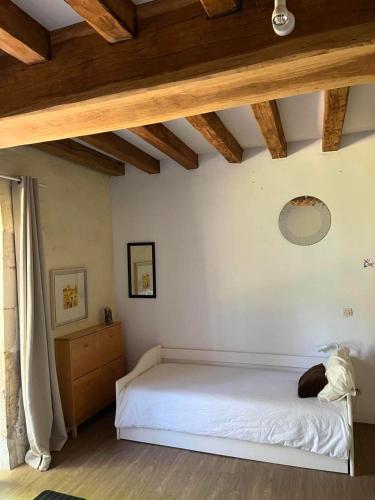 a bedroom with a white bed and a wooden ceiling at L'Aveneau - Havre champêtre avec piscine d'été in Le Retail