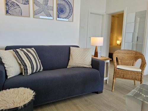 a living room with a blue couch and a chair at Beach House Adria in Bibinje