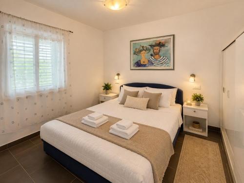 a bedroom with a large bed with towels on it at Apartmani Kuic in Milna