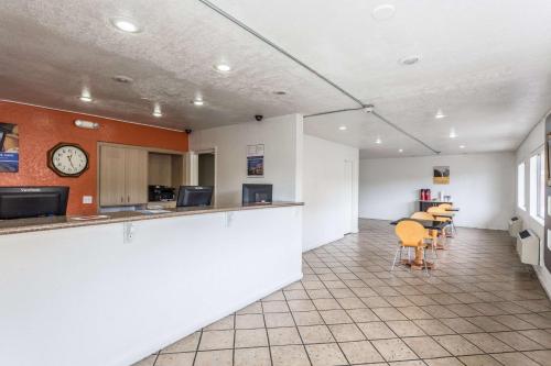 an office with a counter and chairs and a clock at Motel 6 Albuquerque Northeast in Albuquerque