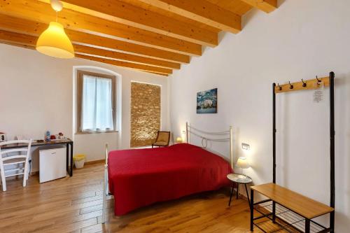 a bedroom with a red bed and a table at Le Logge del Garda in San Felice del Benaco