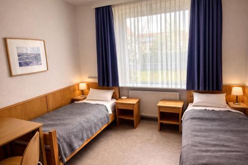 a room with two beds and a window at Wildes Amrum Island Basecamp Backpacker & Nature Stay in Norddorf