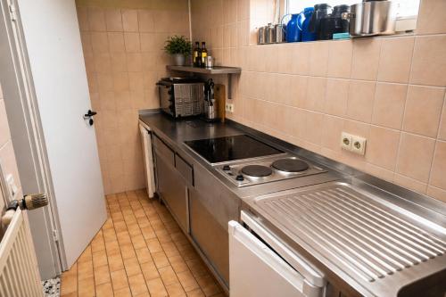 a small kitchen with a stove and a sink at Wildes Amrum Island Basecamp Backpacker & Nature Stay in Norddorf