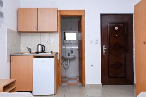 a small kitchen with a sink and a door at Apartments Porto Bjelila in Tivat