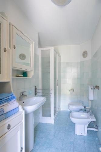a white bathroom with a sink and a toilet at Il Cortile di Mamma Mia in Pisano