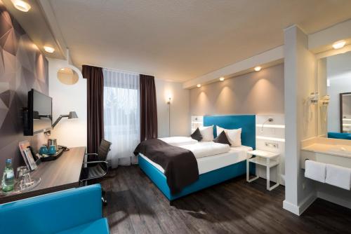 um quarto de hotel com uma cama e uma secretária em Best Western Hotel Cologne Airport Troisdorf em Troisdorf