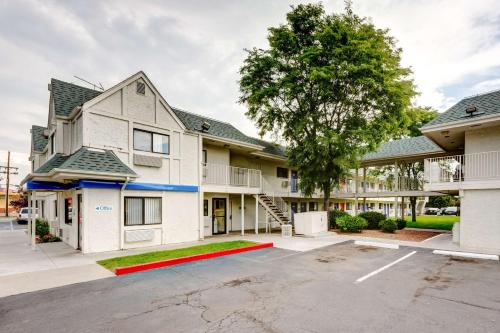 an apartment building with a tree in the parking lot at Motel 6-Wheat Ridge, CO - West - Denver North in Wheat Ridge