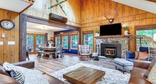 a living room with a fireplace and a tv at Pine Loch, sleeps 9, 3 bedroom, 2 bath, gas fire pit on deck in Pocono Lake