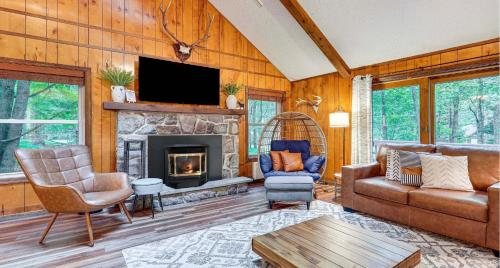 a living room with a couch and a fireplace at Pine Loch, sleeps 9, 3 bedroom, 2 bath, gas fire pit on deck in Pocono Lake