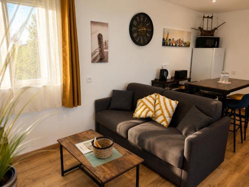 a living room with a couch and a table at Entre parenthèses - Grand confort et Parking privé in Le Fousseret