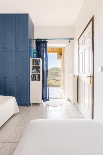 a bedroom with a bed and a door with a window at Sea View Retreat in Oxílithos