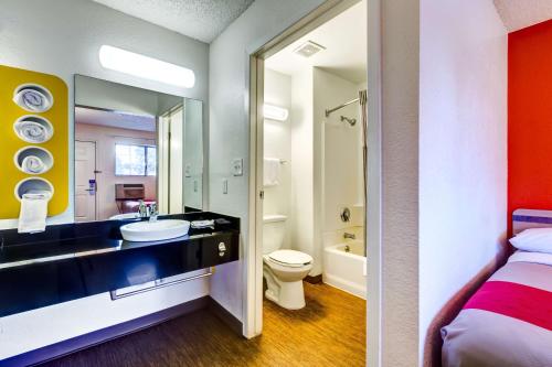 a bathroom with a sink and a toilet and a mirror at Motel 6-Wheat Ridge, CO - West - Denver North in Wheat Ridge