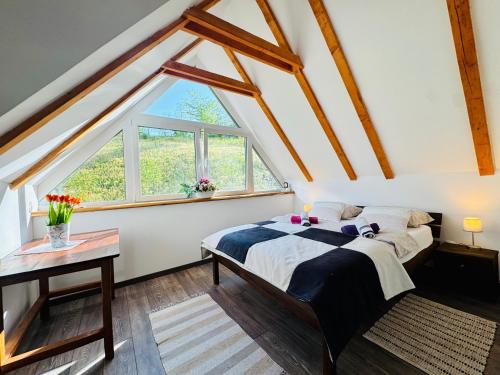 a bedroom with a bed and a window at Green Hills - Holiday Home & Events in Kamenica