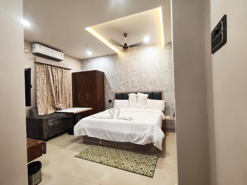 a bedroom with a large white bed and a window at Maa Ambika Royal House in Baripāda