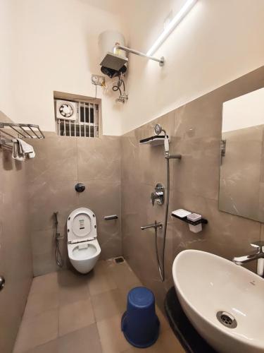 a bathroom with a white toilet and a sink at Maa Ambika Royal House in Baripāda