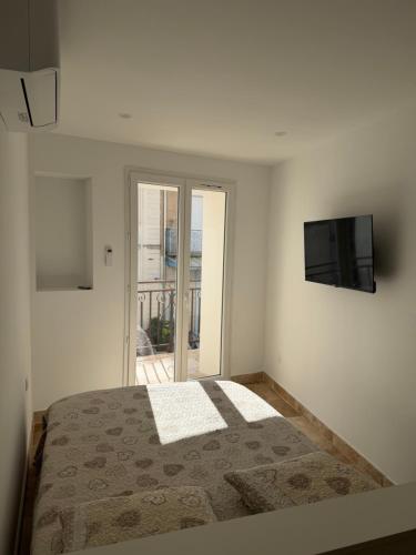 a bedroom with a bed and a flat screen tv at Les remparts de Sasha in Lapalme