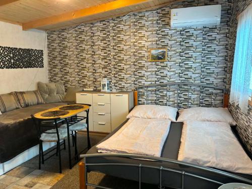a room with two beds and a table and a couch at Chatka v záhrade Mango Chill in Brezno