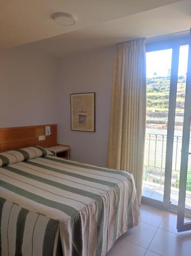 a bedroom with a bed and a sliding glass door at Balcones Azules in Cartagena