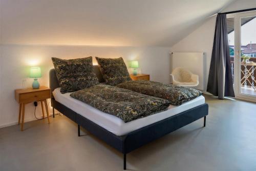 a bedroom with a bed and two lamps and a window at Urlaubsapartment Südsicht in Ihringen