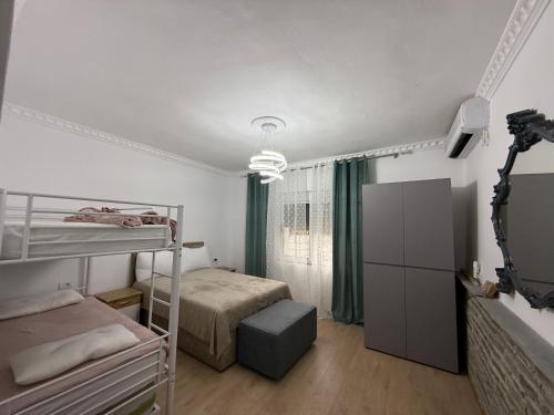 a bedroom with two bunk beds and a television at Canyon River House in Çorovodë