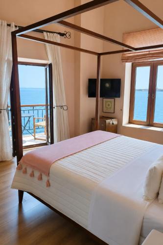 a bedroom with a bed with a view of the ocean at Arion Syros Luxury Rooms and Suites in Ermoupoli