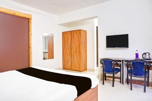 a bedroom with a bed and a table and a tv at Super Collection O Baner Formerly Seven Hills in Pune
