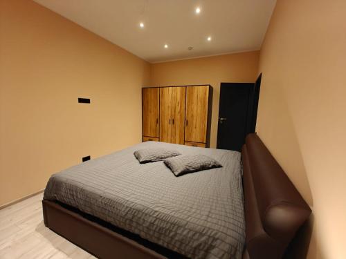 a bedroom with a bed and a wooden cabinet at Vytauto Apartamentai in Biržai
