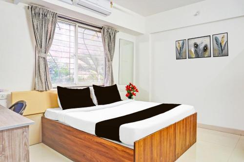 a bedroom with a large bed in front of a window at Super Collection O Baner Formerly Seven Hills in Pune