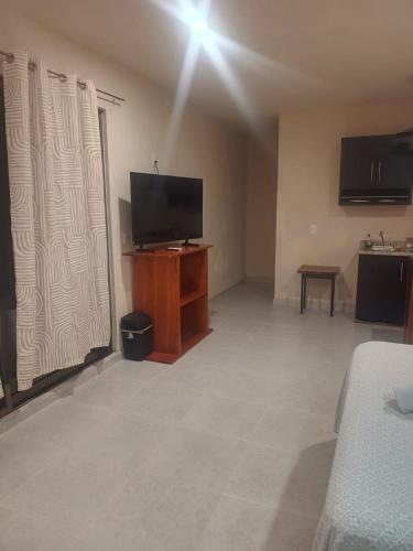 a living room with a flat screen tv on a wooden stand at Miriam Lofts in Bacalar